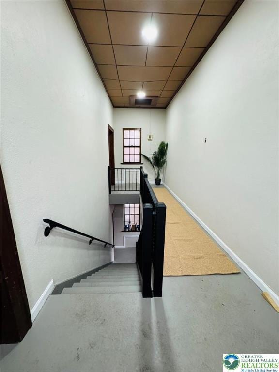 stairs with concrete floors and baseboards
