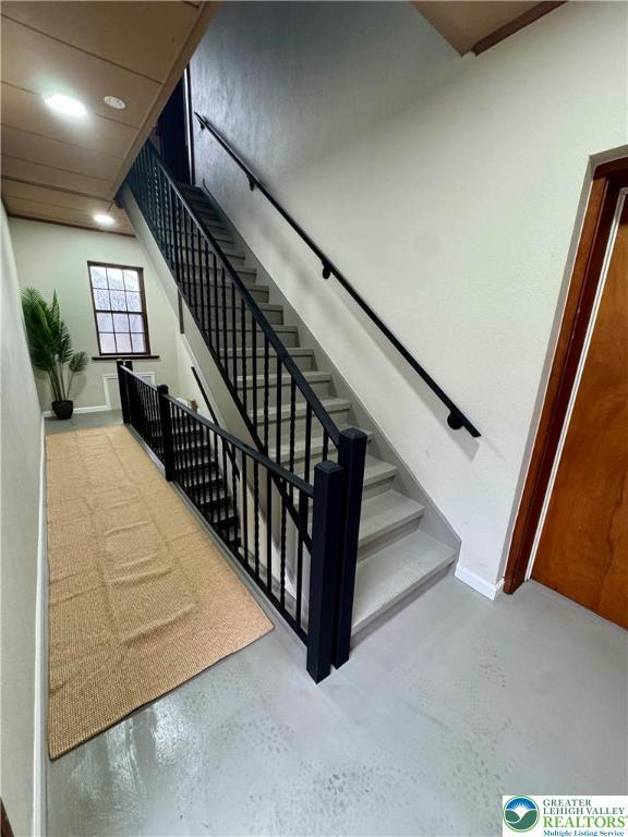 stairway with recessed lighting and baseboards
