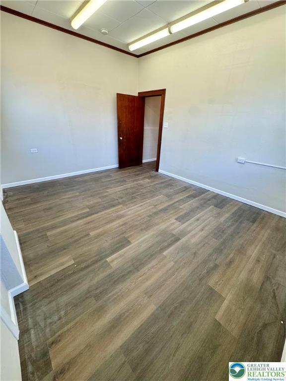 unfurnished room with wood finished floors and baseboards