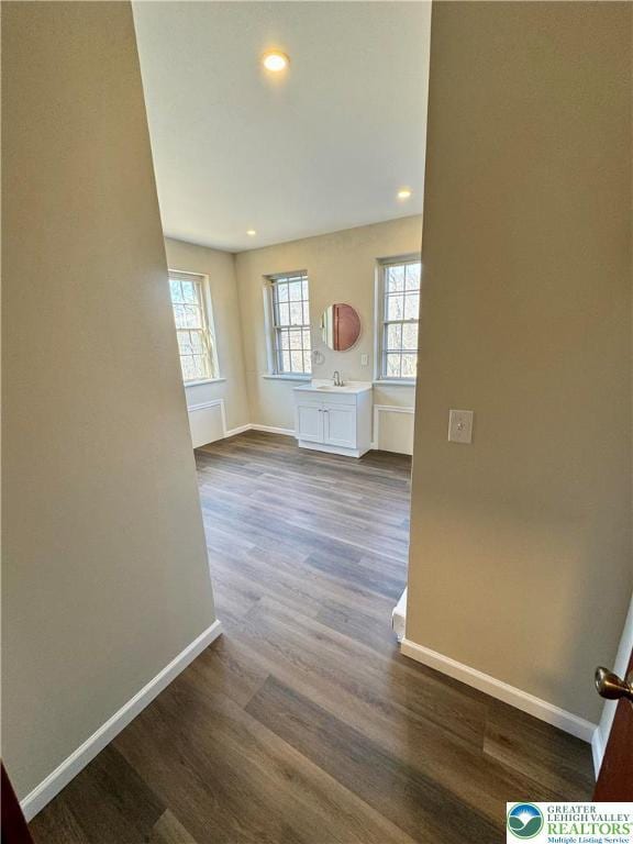 interior space with dark wood-type flooring, baseboards, and recessed lighting