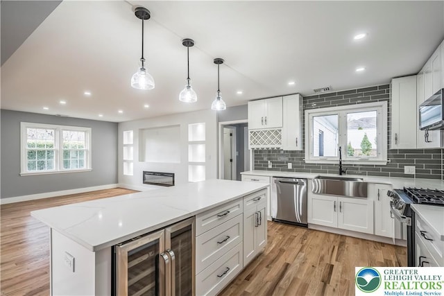 525 N Main St, Allentown City, PA 18104 - kitchen featuring stainless steel appliances, wine cooler, a sink, white cabinets, and tasteful backsplash