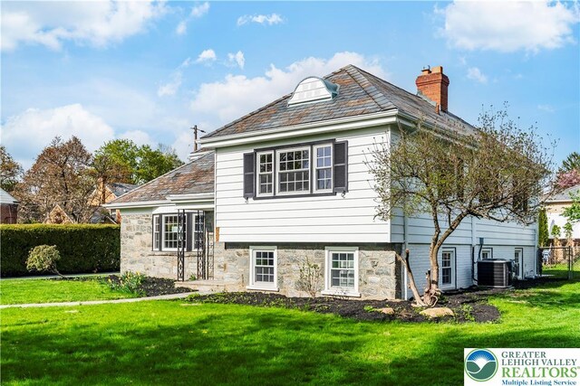 525 N Main St, Allentown City, PA 18104 - view of front of house featuring a high end roof, a chimney, central air condition unit, and stone siding
