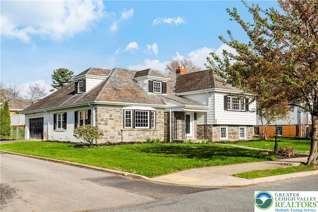 525 N Main St, Allentown City, PA 18104 - view of front of home featuring a chimney, a front yard, an attached garage, and stone siding