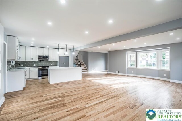 525 N Main St, Allentown City, PA 18104 - unfurnished living room with light wood-style flooring, baseboards, recessed lighting, and stairs