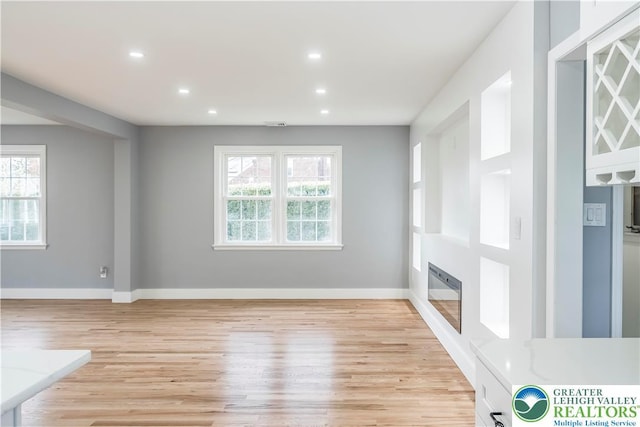 525 N Main St, Allentown City, PA 18104 - unfurnished living room featuring a glass covered fireplace, plenty of natural light, light wood-type flooring, recessed lighting, and baseboards