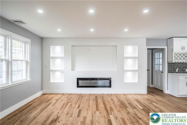 525 N Main St, Allentown City, PA 18104 - unfurnished living room featuring baseboards, built in shelves, a glass covered fireplace, light wood-style floors, and recessed lighting