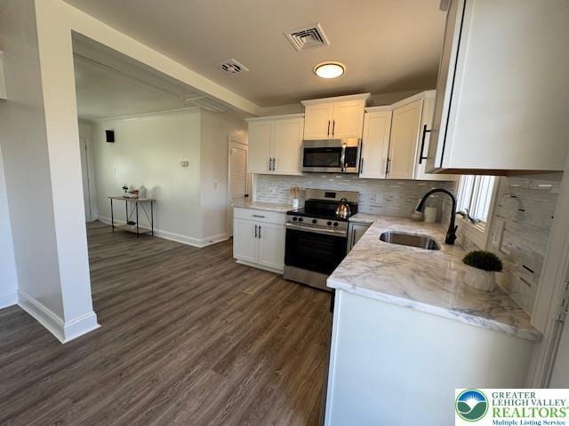 kitchen with white cabinetry, stainless steel appliances, visible vents, and a sink