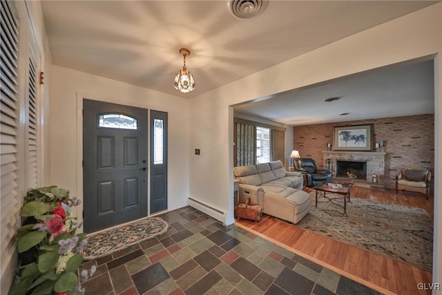 3332 Sherwood Rd, Palmer Twp, PA 18045 - entryway with a fireplace with raised hearth, visible vents, a baseboard heating unit, baseboards, and a chandelier