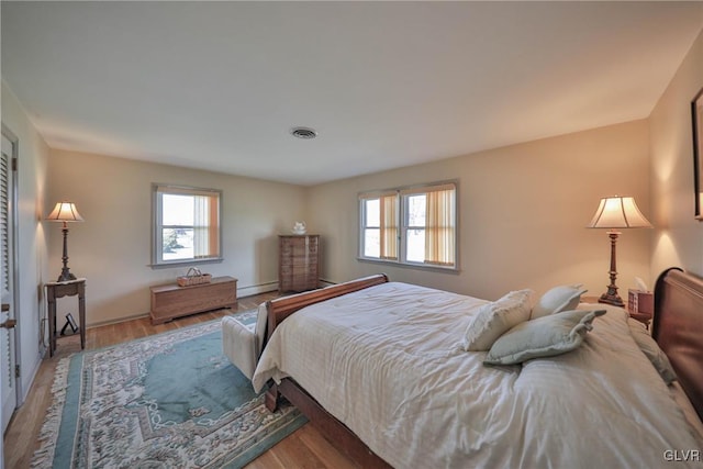 3332 Sherwood Rd, Palmer Twp, PA 18045 - bedroom with a baseboard heating unit, wood finished floors, visible vents, and multiple windows