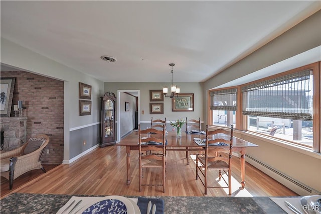 3332 Sherwood Rd, Palmer Twp, PA 18045 - dining area with baseboard heating, wood finished floors, an inviting chandelier, baseboards, and visible vents