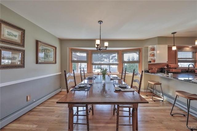3332 Sherwood Rd, Palmer Twp, PA 18045 - dining space featuring a baseboard radiator, a chandelier, light wood finished floors, and baseboards