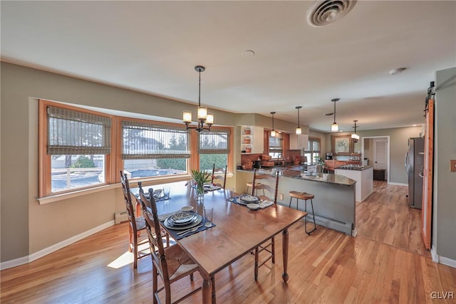 3332 Sherwood Rd, Palmer Twp, PA 18045 - dining space with a baseboard heating unit, visible vents, baseboards, an inviting chandelier, and light wood-style floors