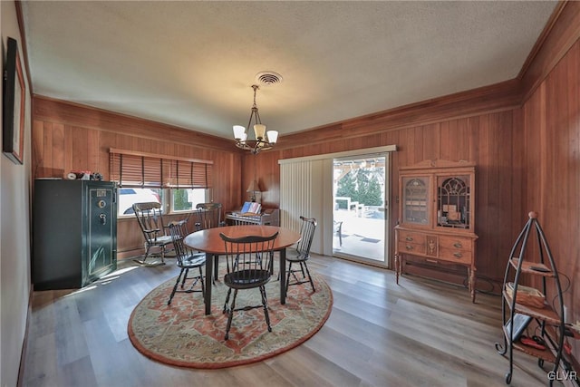 3332 Sherwood Rd, Palmer Twp, PA 18045 - dining area with visible vents, a chandelier, wood finished floors, wooden walls, and ornamental molding