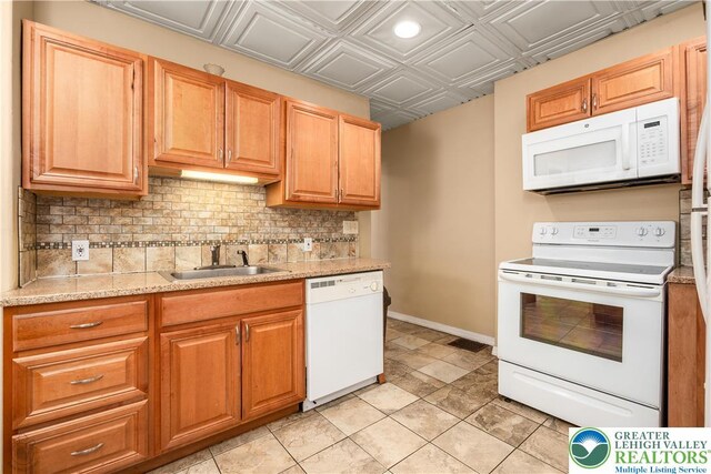 kitchen featuring a sink, white appliances, an ornate ceiling, tasteful backsplash, and baseboards