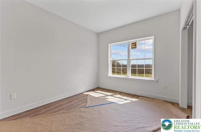 unfurnished bedroom with wood finished floors and baseboards