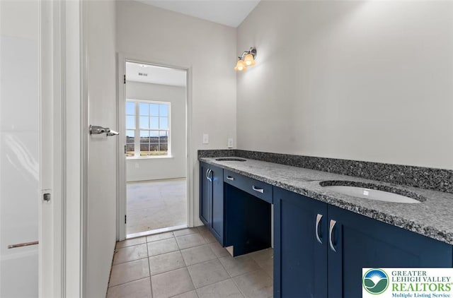 bathroom with tile patterned flooring, a sink, and double vanity