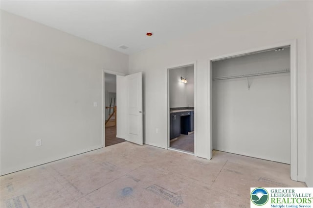 unfurnished bedroom featuring ensuite bath and a closet