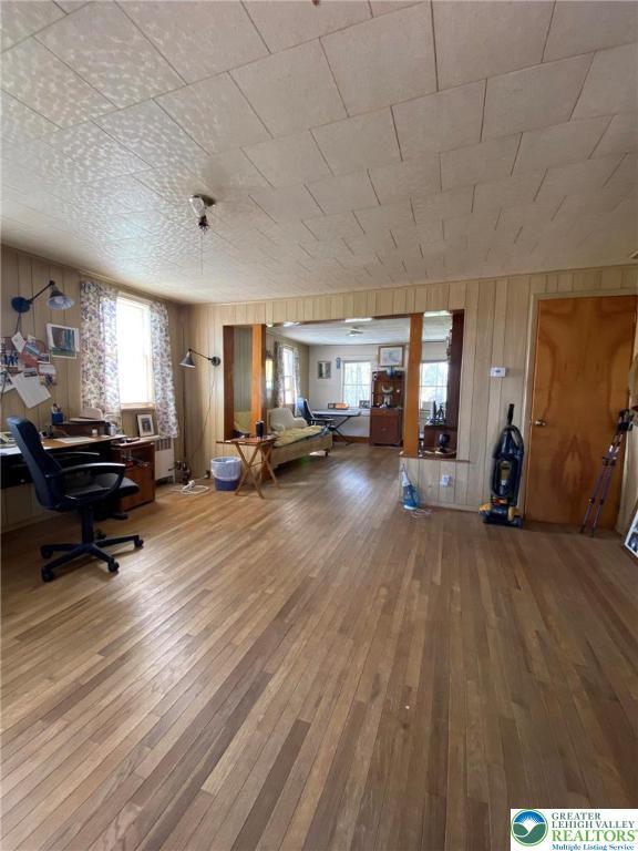 interior space with wood walls and hardwood / wood-style flooring