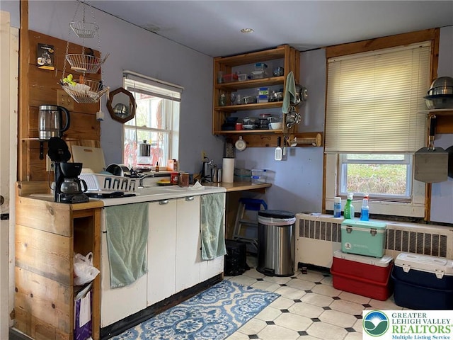kitchen featuring open shelves, light countertops, plenty of natural light, and light floors