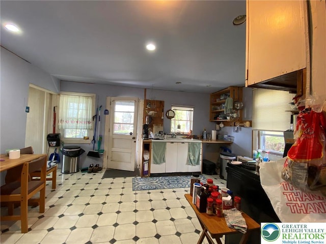 kitchen featuring recessed lighting, light countertops, open shelves, and light floors