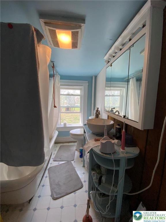 bathroom featuring visible vents, tile patterned floors, toilet, and a sink