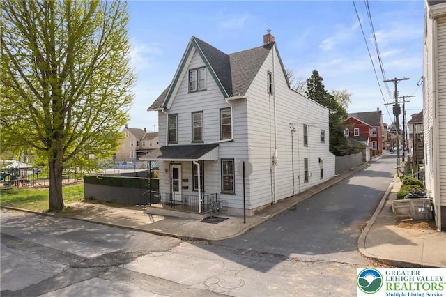 1226 Ferry St, Easton, PA 18042 - view of front of house with a chimney and roof with shingles