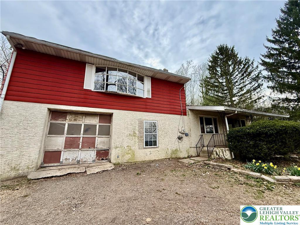 rear view of property with a garage and stucco siding