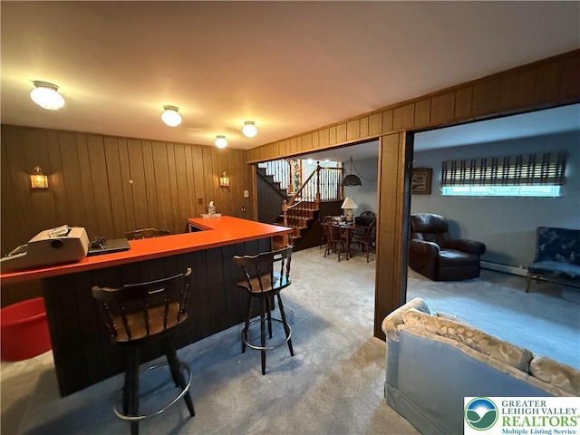 bar featuring wood walls, carpet, stairway, and indoor bar