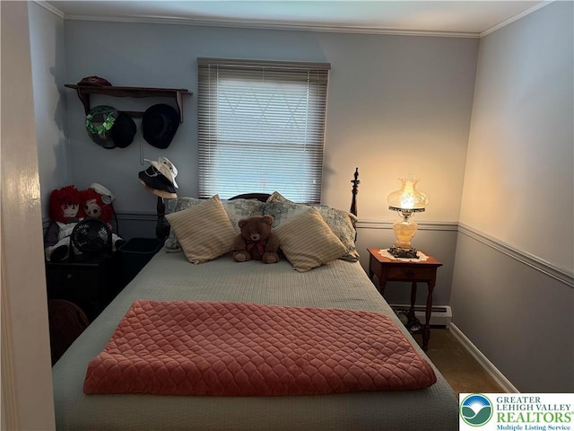 bedroom with a baseboard radiator, baseboards, ornamental molding, and carpet floors