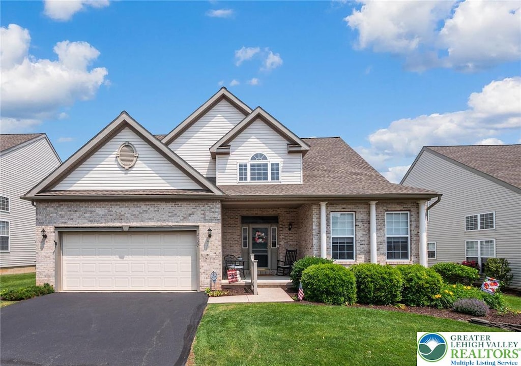 2927 Lifford Ln, Lower Macungie Twp, PA 18062 - traditional-style home featuring brick siding, driveway, a front lawn, a garage, and covered porch