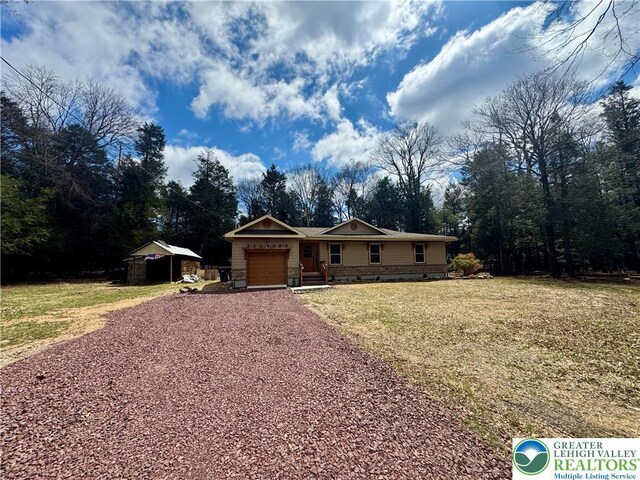 view of front of house with gravel driveway, crawl space, a front lawn, and a garage