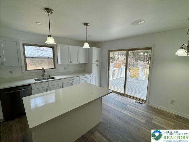 kitchen with a sink, dishwasher, white cabinetry, and light countertops