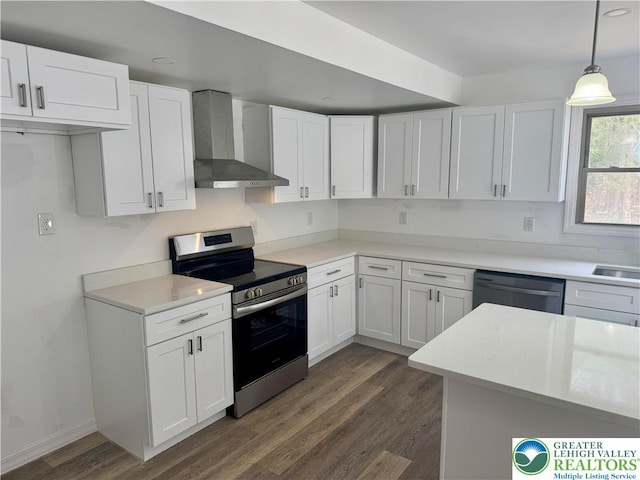 kitchen with appliances with stainless steel finishes, white cabinets, dark wood-style floors, and wall chimney exhaust hood