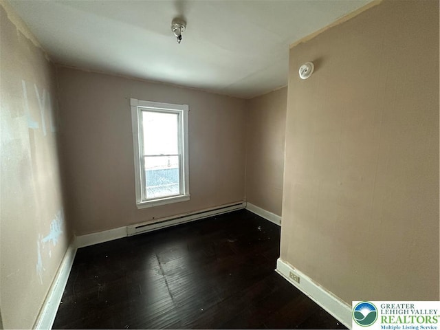 unfurnished room with dark wood-style flooring, baseboards, and a baseboard radiator