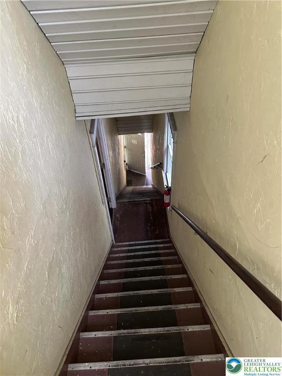 stairs featuring a textured wall