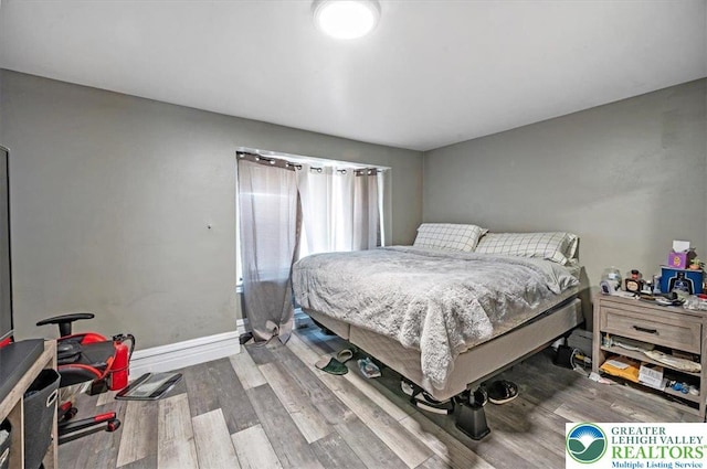 bedroom with baseboards and wood finished floors