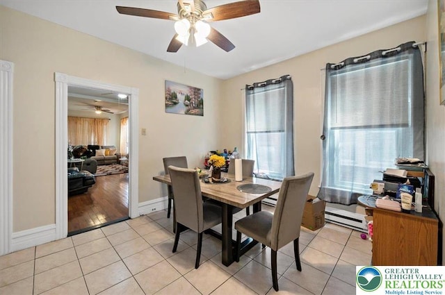 dining space featuring a baseboard radiator, a ceiling fan, baseboards, and light tile patterned floors