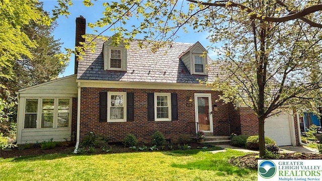 cape cod home featuring a chimney, a front yard, and brick siding