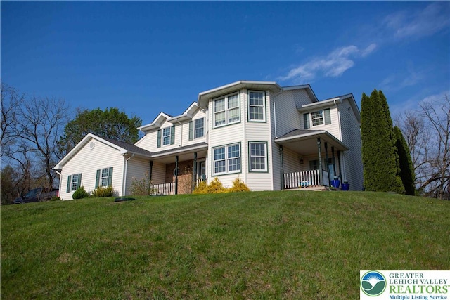 traditional-style house featuring a front yard and a porch