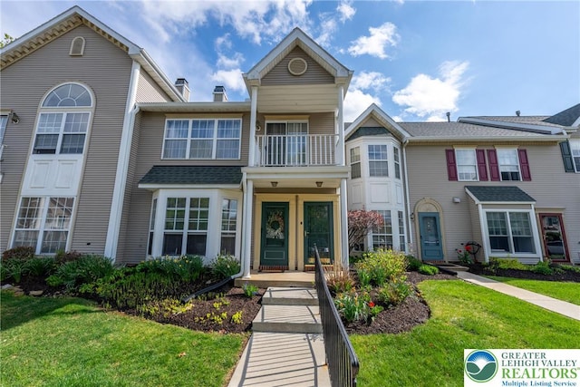 multi unit property with a front lawn and a balcony