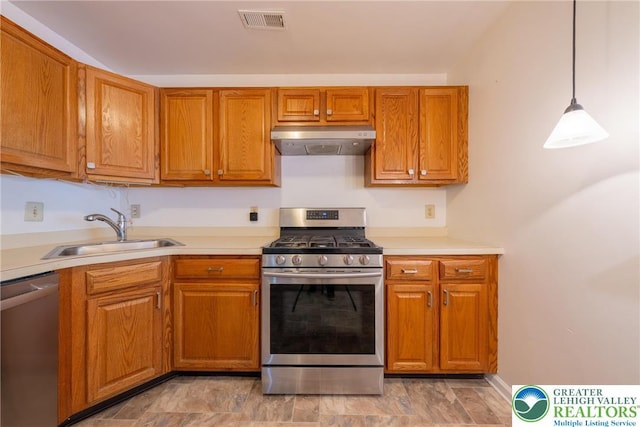 kitchen featuring brown cabinets, a sink, under cabinet range hood, visible vents, and appliances with stainless steel finishes