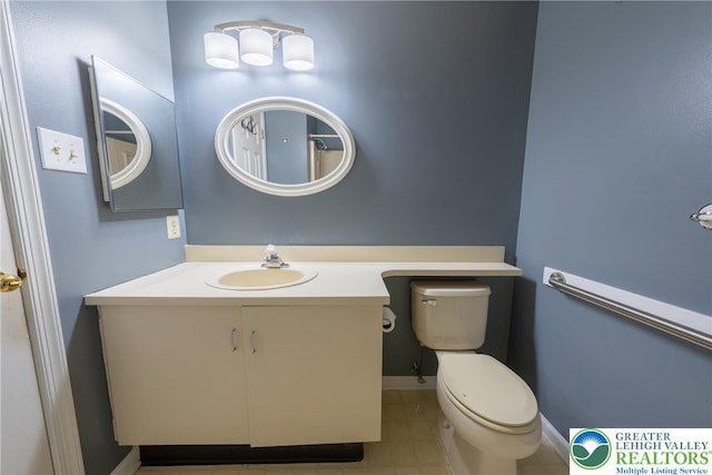 bathroom featuring toilet, tile patterned flooring, vanity, and baseboards