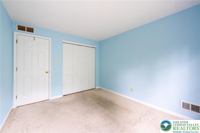 unfurnished bedroom featuring a closet, visible vents, carpet floors, and baseboards