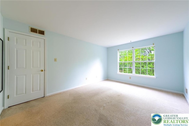 spare room with visible vents, carpet floors, and baseboards