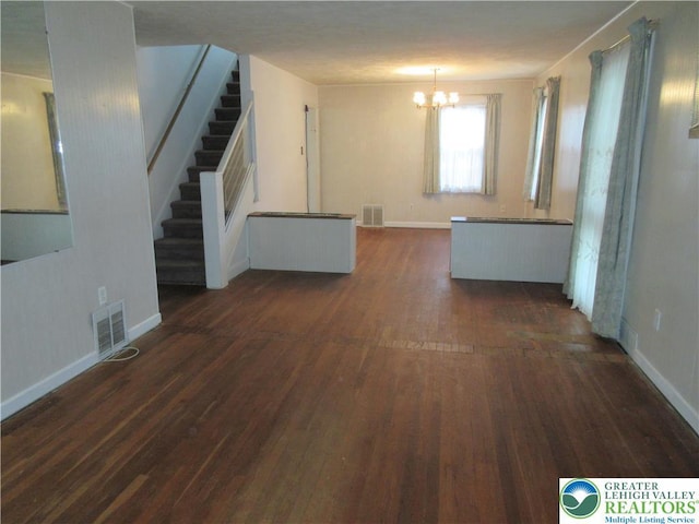 unfurnished living room with stairway, visible vents, dark wood-style floors, baseboards, and an inviting chandelier