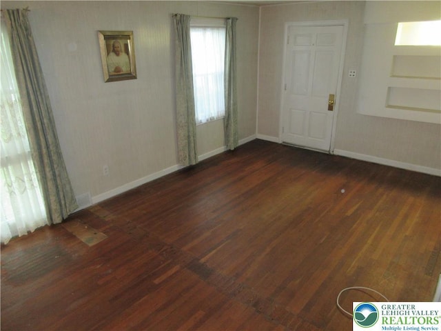 empty room featuring baseboards and wood finished floors