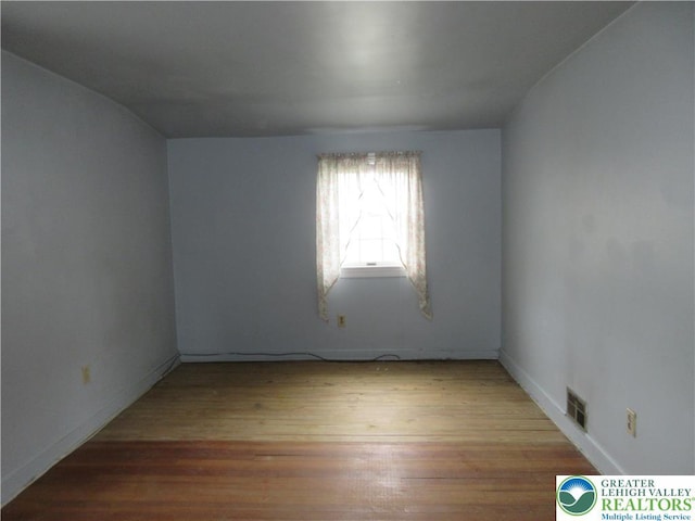 unfurnished room with baseboards, visible vents, and light wood finished floors