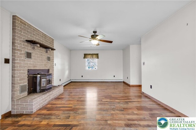 unfurnished living room with a wood stove, visible vents, baseboards, wood finished floors, and a ceiling fan