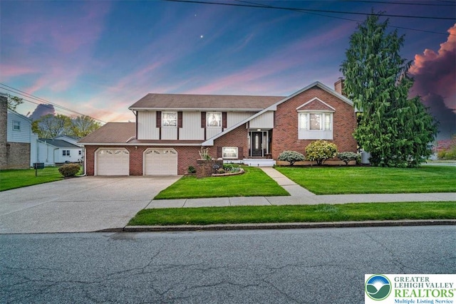 view of front facade featuring a chimney, concrete driveway, a front yard, and brick siding