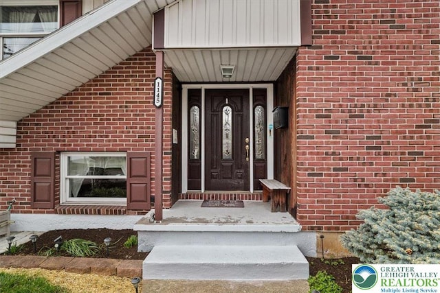 entrance to property featuring brick siding